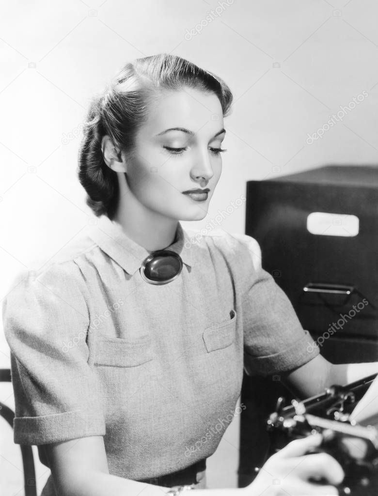 Young beautiful typist at work