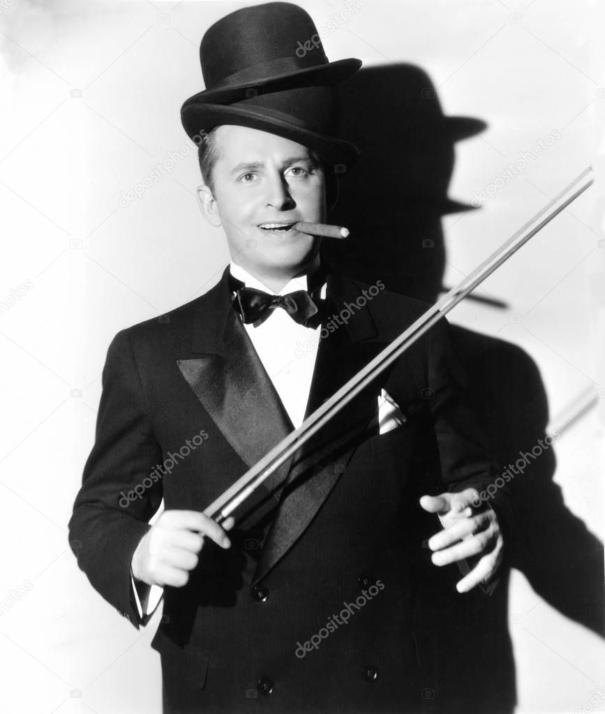 Man wearing an extra hat holding a violin bow