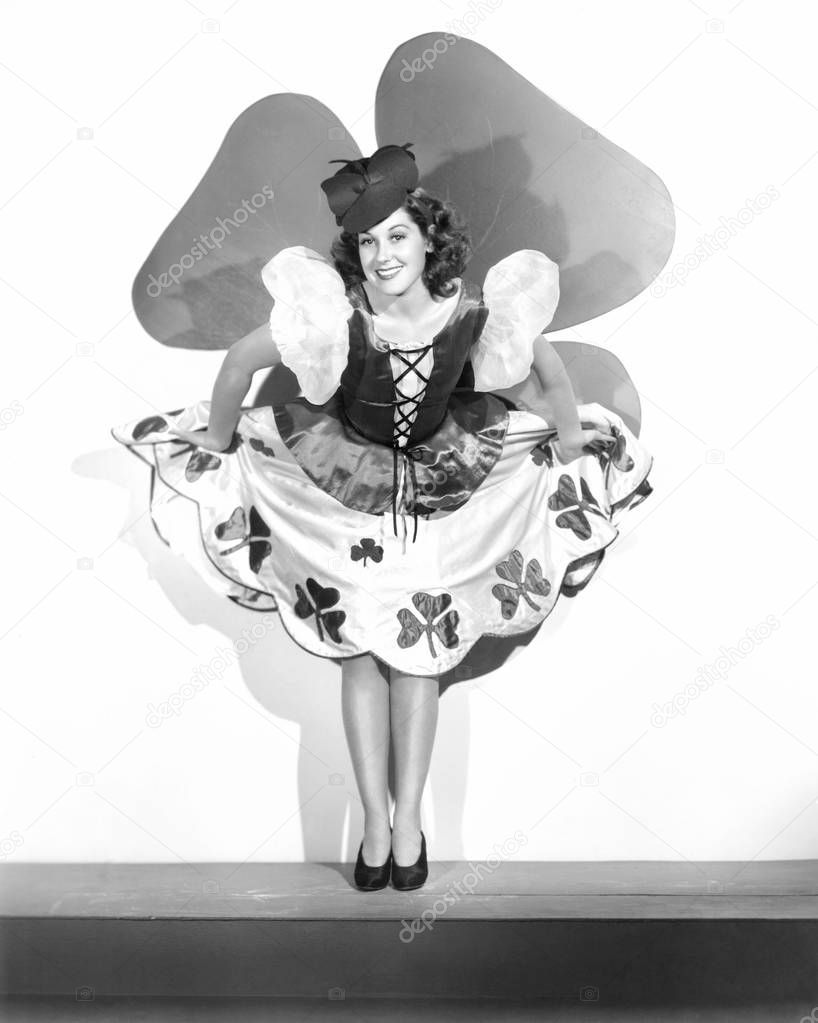 Woman lifting her festive dirndl dress decorated with shamrocks