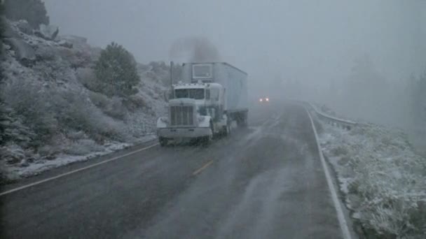 二十世纪八十年代暴风雪期间在山区公路上行驶的拖拉机拖车 — 图库视频影像