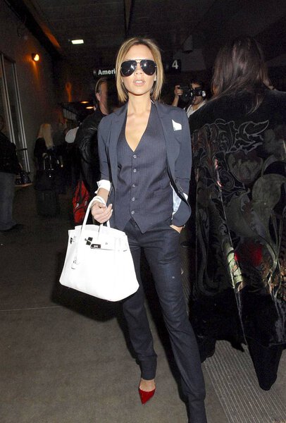 Виктория Бекхэм (с сумкой Hermes Birkin) из и около для CANDIDS - Виктория Бекхэм прибывает в аэропорт LAX, аэропорт LAX, Лос-Анджелес, Калифорния, 13 февраля 2007. Фото: Maximillion / Everett Collection
