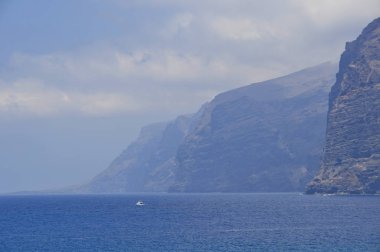 Tenerife - Los Gigantes kayalıklarla, okyanus ve küçük yaht