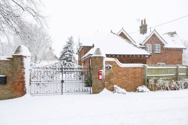 Entrance to an English country house exterior covered in snow in winter clipart