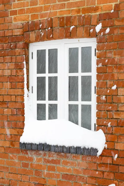 冬天的雪覆盖着英国一座旧砖房的窗户 — 图库照片