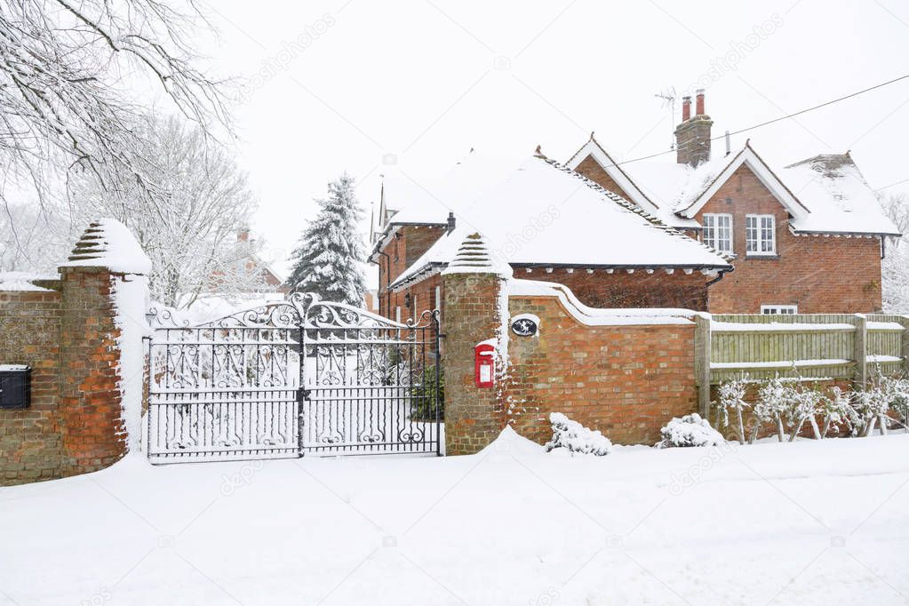 Entrance to an English country house exterior covered in snow in winter