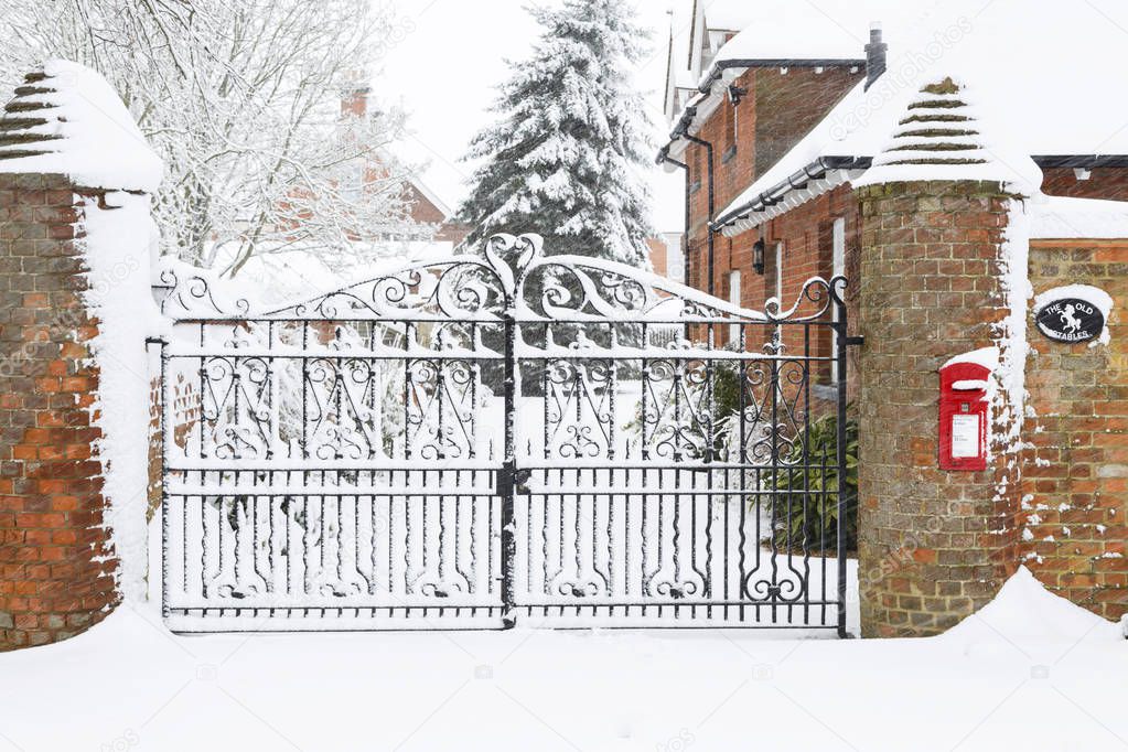 Victorian iron gates to a large English house in snow at Christmas
