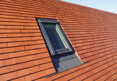 VELUX türü çatı ışık penceresinde bir geleneksel düz kil kiremit evin çatı