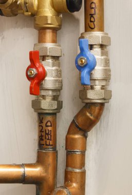 Yalıtım vana ile sıcak ve soğuk bakır su boruları. Sıhhi tesisat ve su gösteriyor