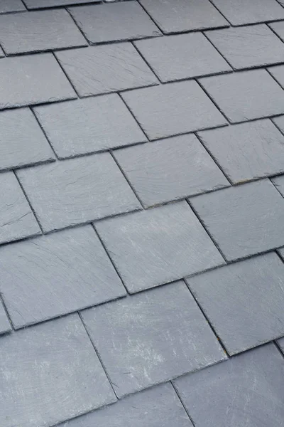 Detail of traditional gray slate roof tiles on a pitched roof