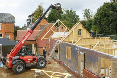 Buckingham, İngiltere - 13 Ekim 2016. Ağır makine bir çatı makas yerine bir dönem ev uzantısı üzerinde kaldırdı. Ahşap çerçeve yapılar uzantısıdır.