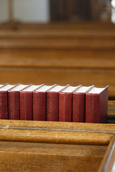 Detail Eines Kircheninnenraums Eine Reihe Roter Gesangbücher Auf Einer Kirchenbank — Stockfoto