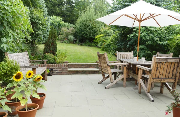 Patio con mobili da giardino e ombrellone — Foto Stock