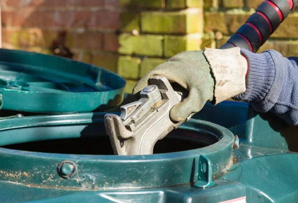 英国の田舎の家で国内加熱油 でバンドオイルタンクを埋める男の閉鎖 — ストック写真