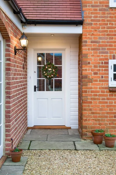 英国一所房子的半玻璃门上挂着圣诞花环 — 图库照片