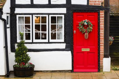 WINSLOW, İngiltere - 26 Aralık 2019. Noel çelengi ve dekorasyonlar miras evi, İngiltere 'deki yazlık ev, kışlık sokak manzarası