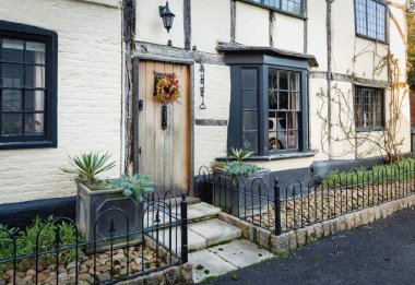 WINSLOW, UK - December 29, 2019. Facade of English period house or cottage in a historic UK town, with small front garden in Christmas, winter clipart