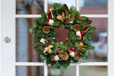 Closeup, detail of a Christmas wreath on traditional front door of a home in UK clipart