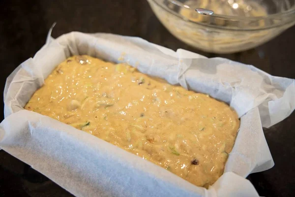 Courgette zucchini loaf cake mixture in a tin (before baking)