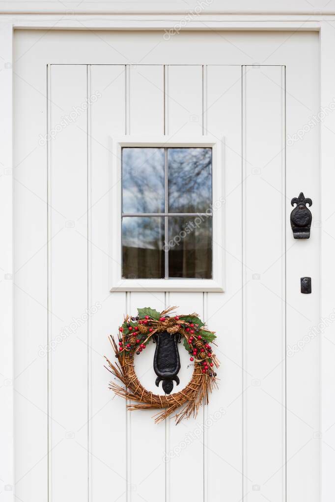 Off white, offwhite, gray, grey wooden painted front door with leaded glass and Christmas garland, UK