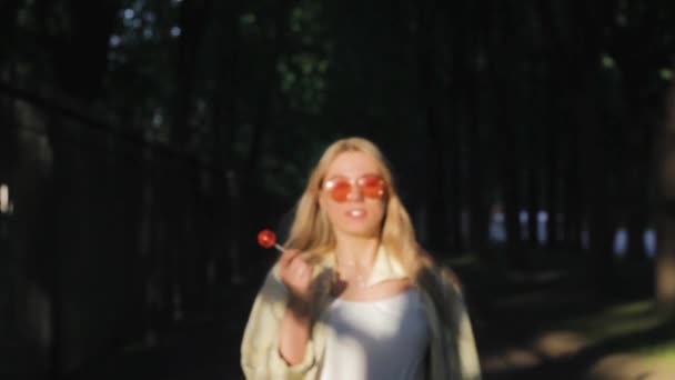 Meisje Walking Zuigen Lollipop Aantrekkelijk — Stockvideo