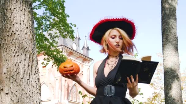 Czarownica Czyta Księgę Zaklęć Utrzymuje Święta Dyni Halloween — Wideo stockowe