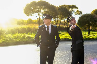 Gün batımında pilotlar yakışıklı destansı üniforma taşımacılığında