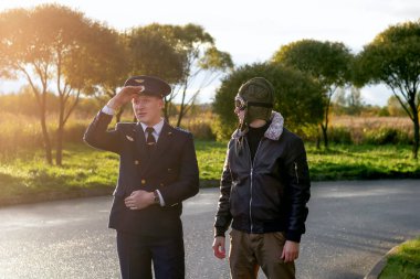 Gün batımında eski pilotlar. Yakışıklı destansı üniforma taşımacılığı.
