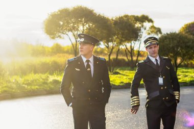 Gün batımında pilotlar yakışıklı destansı üniforma taşımacılığında
