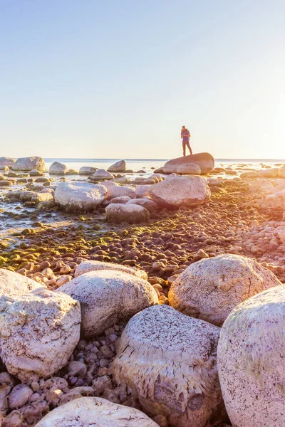man stands on a stony coastline at dawn inspiring by life
