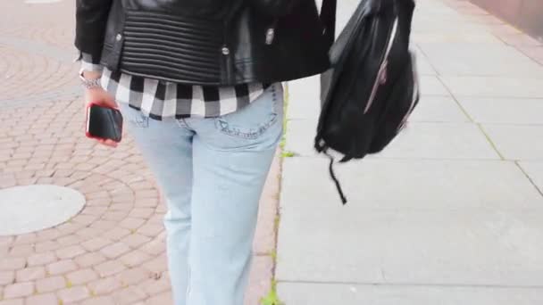 魅力的な女の子は流行のバックパックとスニーカーの靴で街を歩く — ストック動画