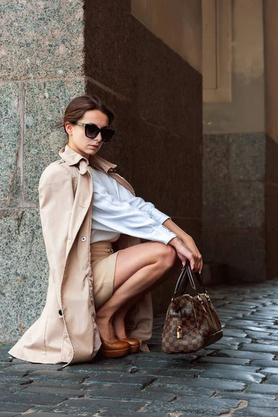 年轻性感的时髦女孩坐在外套品牌的皮鞋风格 — 图库照片