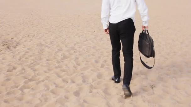 Mężczyzna w garniturze i butach jeździ wzdłuż plaży — Wideo stockowe
