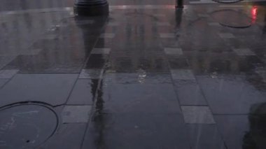 Yayalar yağmurlu bir kaldırımda yürür şehir yansıması rengarenk