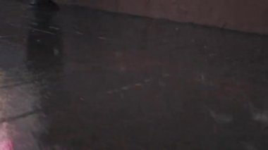 Yayalar yağmurlu bir kaldırımda yürür şehir yansıması rengarenk