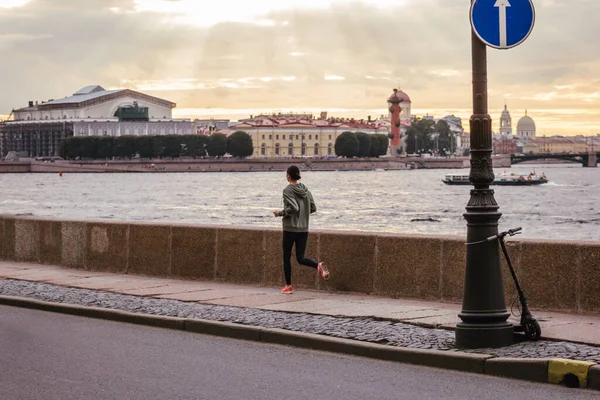 girl jogger running along the embankment in the sunset inspired