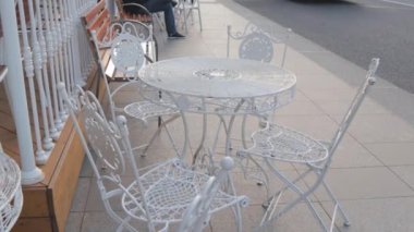 Sahte beyaz metal sandalyeler ve kafe masaları veranda klasik yazı
