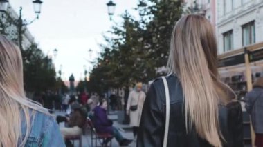 İki kız öğrencinin kız arkadaşı sokakta birlikte yürüyor.