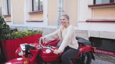 Çekici genç kız seksi kırmızı motosiklet macerası cazibesine sahip oturuyor.