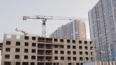 Yüksek binaların inşaatçıları kollektif inşaat endüstrisi profesyonel vinç üst üste bindiriyorlar.