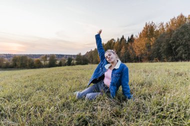 Gün batımında poz veren kız özgürlük doğası neşeli kırsal kesim
