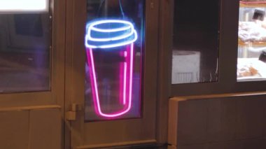 Gece barındaki kahve dükkanının camında neon ikon tabelalı kahve parlıyor.