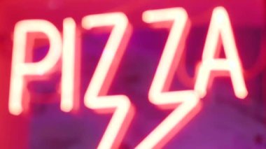 Pizzacının camındaki neon pizza yazıları geceleri parlıyor.