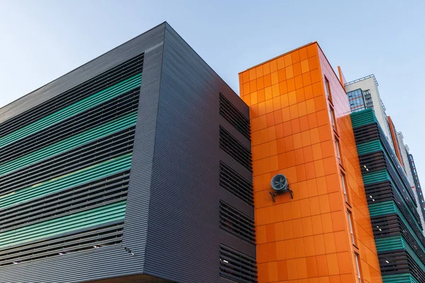 Building in architectural style high-tech bright colors.orange bar panel facade parking