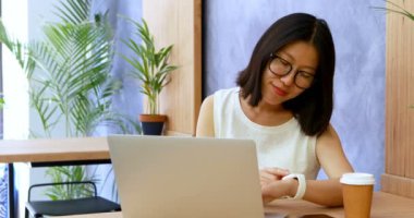 Kadın executive Office 4 k masasında çalışırken smartwatch zamanında kontrol