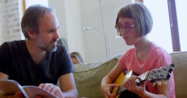 Babası kızının ev 4 k oturma odasında gitar çalmayı yardım