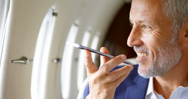 Зрелый Бизнесмен Разговаривает Мобильному Телефону Время Путешествия Частном Самолете — стоковое видео