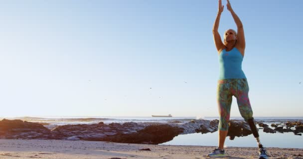 在阳光明媚的日子 在海滩上做瑜伽的残疾妇女4K — 图库视频影像
