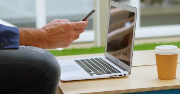Empresário Usando Celular Wile Trabalhando Laptop Escritório — Vídeo de Stock