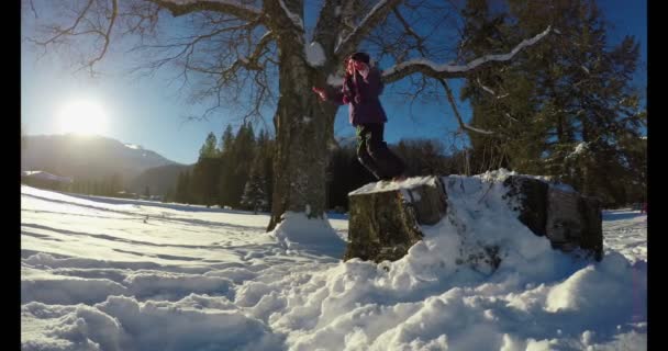 在阳光明媚的日子冬天在雪地里玩耍的女孩4K — 图库视频影像