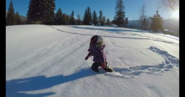 Criança Fazendo Anjos Neve Neve Durante Inverno Dia Ensolarado — Vídeo de Stock